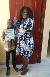 A mother with her 2 ED children in Kenya, the eldest holding our everybody's different book. Mum is holding baby boy