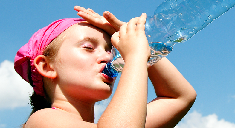 girl drinking a bottle of water in the sun